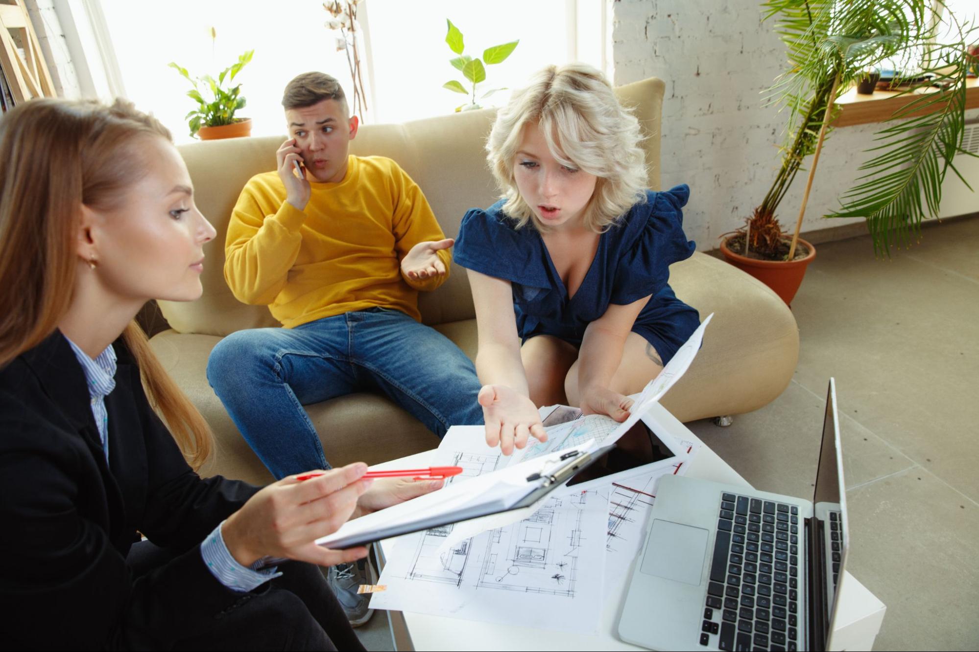 woman-seeing-blueprints-man-talking-phone
